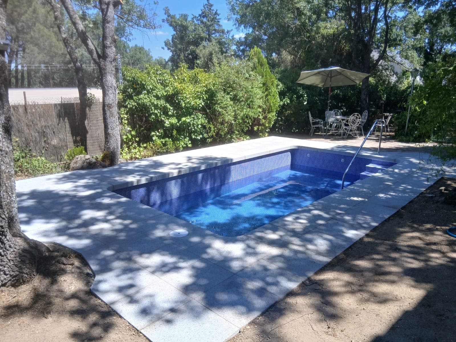 Piscina exterior con ducha y solado